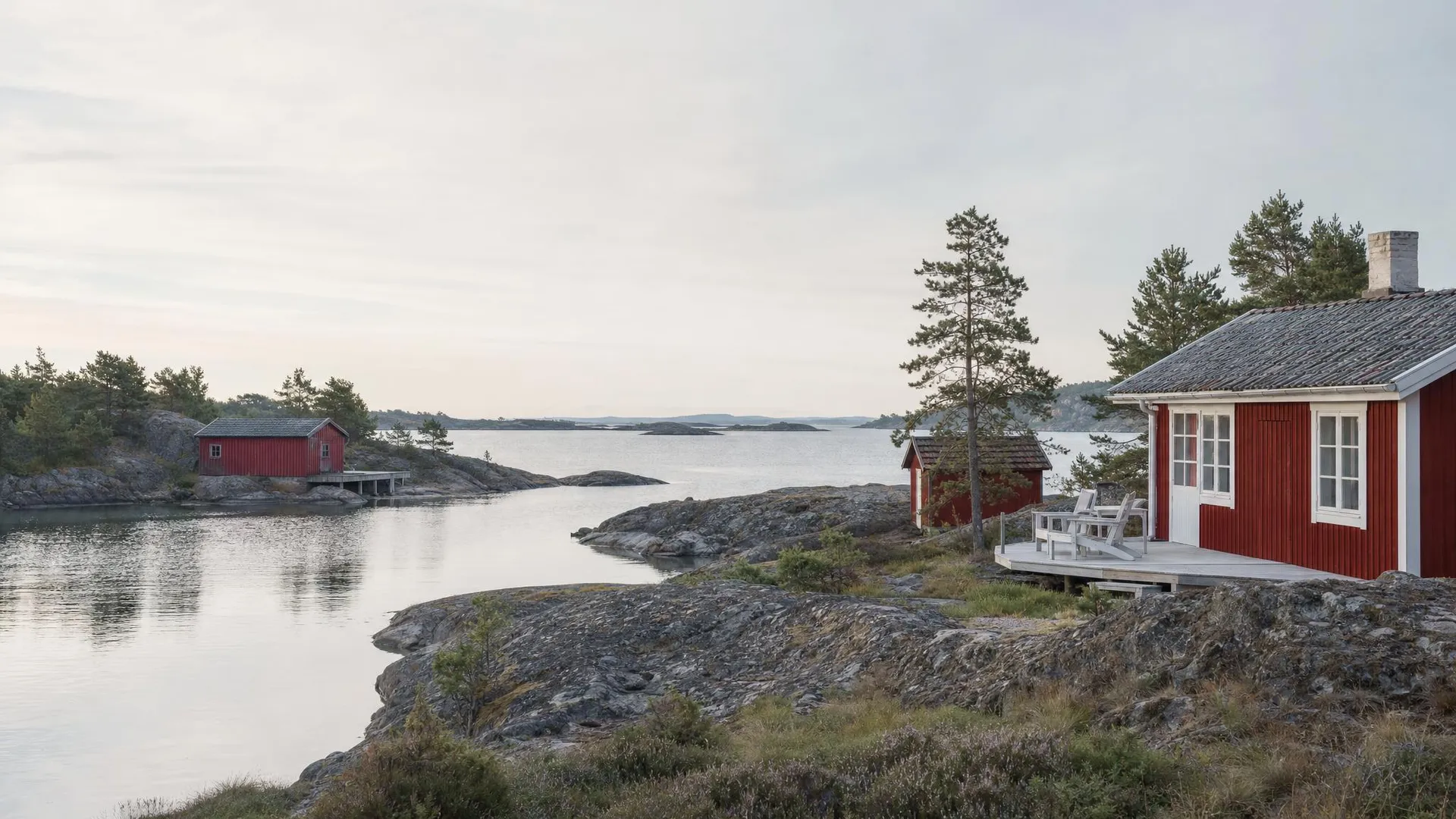 Skärgårdsstrand med faluröda trähus, granithällar och tallar i Stockholms län