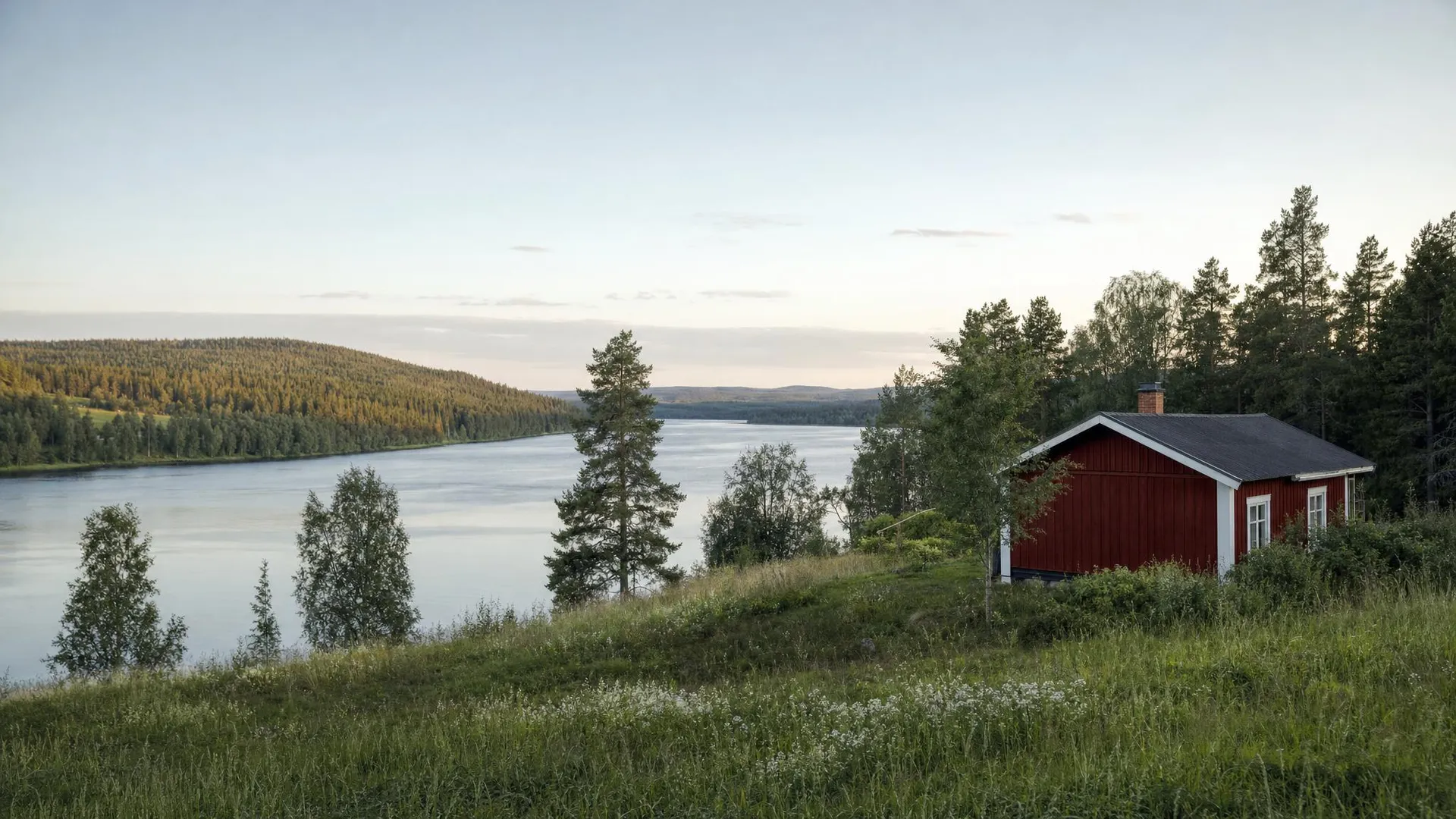 Älvdal med rött hus och tallskog i Västerbottens län