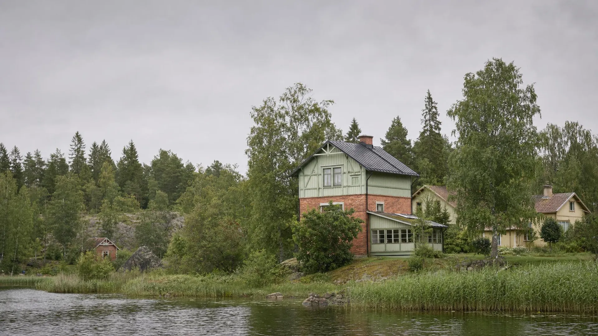 Västmanländskt landskap med sjö, villa och blandskog i Västmanlands län